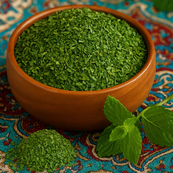 بلغور نعنا در یک پیاله چوبی که کنارش گوشه سمت راست پایین برگ نعنا دیده می شود و روی پارچه آبی قرمز سنتی قرار دارد. عرضه محصولات عطاری آنلاین مستر هِل